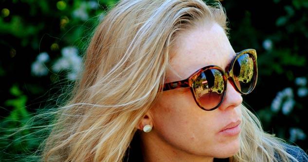 Woman wearing sunglasses, unhappy